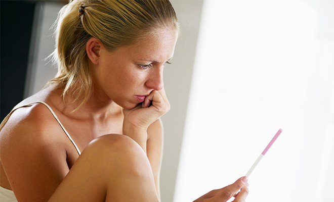 The article explores what to do after failed IVF. The featured image depicts a woman examining a pregnancy test.