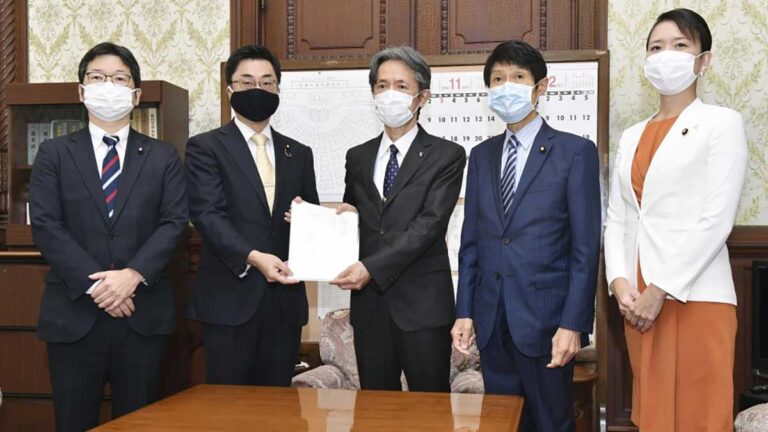 Takashi Okamura (C), secretary general of the House of Councillors, receives a bill from representatives of Japan's ruling and opposition parties on Nov. 16, 2020, in Tokyo, to recognize those who give birth to a baby from donated eggs or sperm as its legal parents