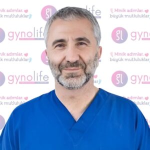 Hyat Izel, founder and obstetrics and gynecology specialist, wearing blue scrubs at Gynolife IVF Center with clinic logo background