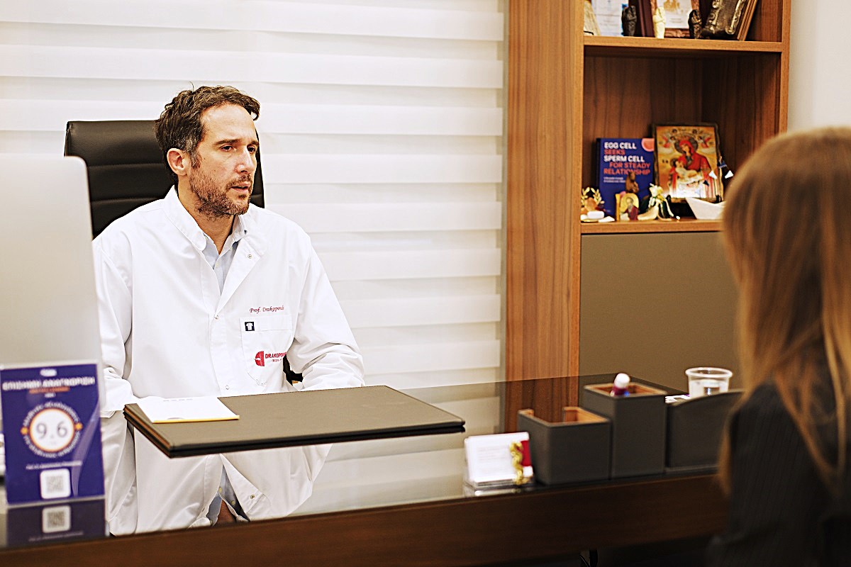 Drakopoulos Reproductive Medicine 3 Fertility specialist in white coat talking with a female patient during IVF consultation at Drakopoulos Reproductive Medicine clinic in Athens, Greece – infertility treatment, gynecology, reproductive medicine.