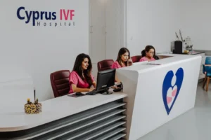 Inside a medical clinic, several staff members sit behind a computer desk.