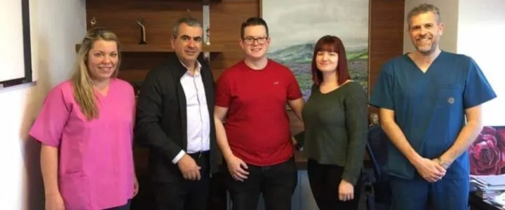 IVF Greece Reviews: Is Greece the Right Destination for IVF Treatments? 1 A couple stands together inside a medical clinic, beside doctors.